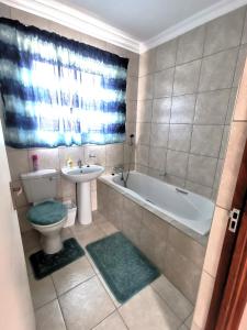 een badkamer met een bad, een toilet en een wastafel bij MV self-catering - Units in Bloemfontein