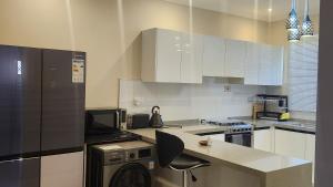 a kitchen with white cabinets and a dishwasher at Chez Gabrielle in Lusaka