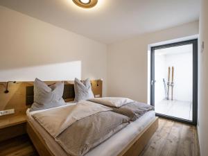 Un dormitorio con una cama con paredes blancas y una ventana en Bachgeflüster, en Itter