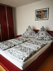Cama con sábanas y almohadas blancas y negras en Haus Mila, en Freudenstadt
