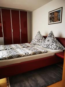 a bed with black and white pillows in a room at Haus Mila in Freudenstadt