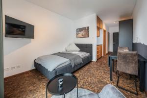 a bedroom with a bed and a desk in a room at Baker`s Home in Augsburg