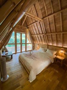 a bedroom with a large bed in an attic at Aksha Riverside Ubud in Tampaksiring