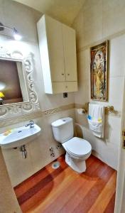 La salle de bains est pourvue de toilettes blanches et d'un lavabo. dans l'établissement Holibai, Lembrare, El Mirador Del Mar, Ático, à Baiona