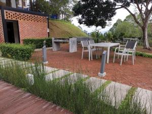 een picknicktafel en stoelen in de tuin bij Belle Vue 408 Genting View Resort in Genting Highlands