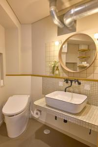 La salle de bains est pourvue de toilettes, d'un lavabo et d'un miroir. dans l'établissement BANBOO HOUSE, à Osaka
