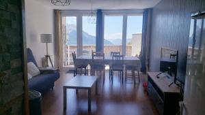 salon ze stołem, krzesłami i kanapą w obiekcie Appartement Le soleil des Alpes w mieście Orcières