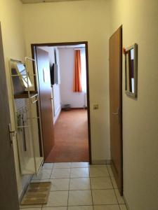 einen Flur mit einer Tür, die zu einem Zimmer führt in der Unterkunft Pension Claudia in Vösendorf