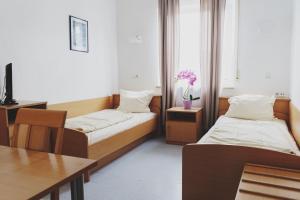 ein Hotelzimmer mit 2 Betten, einem Tisch und einem sidx sidx in der Unterkunft Gasthof Kirchberger in Fürth