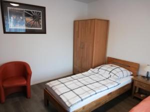 a small bedroom with a bed and a chair at Jagdhaus Weber in Herscheid