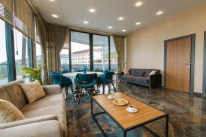 a living room with a couch and a table and chairs at Fevzi Hoca Otel in Trabzon