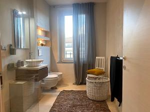 baño con lavabo y aseo y ventana en Francesca's Minimal-Chic Design apartment, en Montecatini Terme