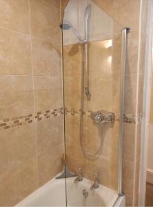 a shower with a glass door next to a sink at Victorian Terraced House in Salisbury; 3 bedrooms in Salisbury