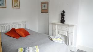 a bedroom with a bed with two pillows and a fireplace at Victorian Terraced House in Salisbury; 3 bedrooms in Salisbury