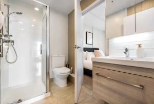 a bathroom with a shower and a toilet and a sink at Skytower view and Seaview 2 bedroom Apartment in Auckland