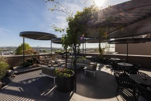 a patio with tables and chairs and umbrellas at Hafnerhotel - Das Kachelofen-Wohlfühlhotel in Wieselburg