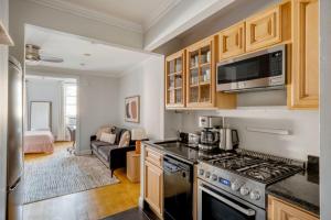 a kitchen with a stove top oven next to a living room at West Village 2br w in-unit wd nr shops NYC-1256 in New York