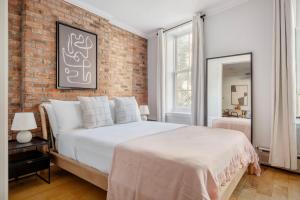 a bedroom with a brick wall and a bed at West Village 2br w in-unit wd nr shops NYC-1256 in New York