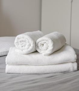 two towels are stacked on top of a bed at Saska Kępa Comfort Apartment in Warsaw