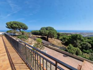 a balcony with trees and the ocean in the background at Villa Maresme & Villa Rosa in Mataró