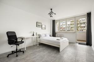 a bedroom with a bed and a desk and a chair at Saska Kępa Comfort Apartment in Warsaw