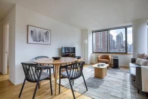 a living room with a table and chairs and a couch at UES 2br w elevator doorman nr transportation NYC-1297 in New York