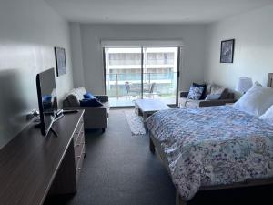 1 dormitorio con 1 cama, TV y sofá en Waves 348 - Free WiFi - Late CheckOut - Garage, en Cowes