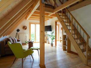 uma sala de estar com uma escada e uma cadeira verde em Heimatglück em Lautenbach