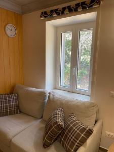 a living room with a couch and a clock on the wall at Garden Rovinj in Rovinj