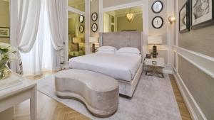 a bedroom with a white bed and a table at Grand Hotel Principe Di Piemonte in Viareggio