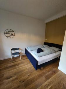 1 dormitorio con 1 cama y 1 silla en Almelose Kanaal, en Zwolle