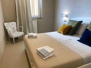 1 dormitorio con 1 cama grande con silla y ventana en Francesca's Minimal-Chic Design apartment, en Montecatini Terme