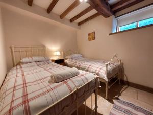 two twin beds in a room with a window at Camps Heath Barn in Lowestoft