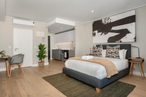 a bedroom with a large bed and a kitchen at 7 on Bantry Apartments in Cape Town