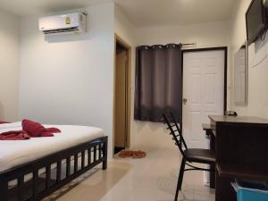 a bedroom with a bed and a desk and a chair at Kitty Guesthouse in Phi Phi Islands