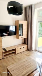 Il comprend un salon doté d'une télévision à écran plat et d'une table. dans l'établissement Apartmán BB-Centrum1, à Banská Bystrica