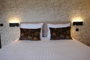 1 dormitorio con 1 cama blanca y 2 almohadas en Les Restanques du lac en La Chapelle