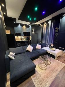 - un salon avec un canapé bleu et une table dans l'établissement Suite64 - Jacuzzi privatif, à Neuilly-sur-Seine