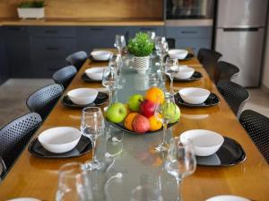 a long table with glasses and a bowl of fruit on it at Villa Jelena in Kastel Novi