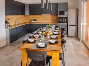 a large wooden table in a kitchen with a long dining room at Villa Jelena in Kastel Novi