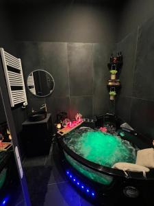 a bathroom with a tub filled with green water at Suite64 - Jacuzzi privatif in Neuilly-sur-Seine