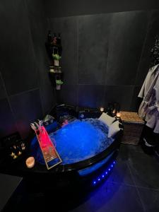 a hot tub with blue water in a room at Suite64 - Jacuzzi privatif in Neuilly-sur-Seine