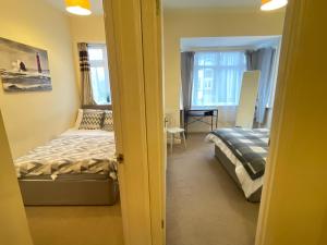 een slaapkamer met een bed, een bureau en een raam bij Cosy city retreat in Portsmouth