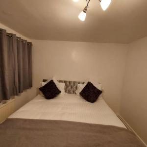 Un dormitorio con una cama con dos almohadas encima. en The Rose, en Greasbrough