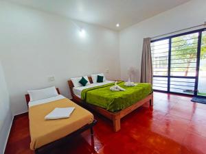 a bedroom with two beds and a window at STAYMAKER Sereno Resort in Sakleshpur