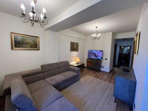 a living room with a couch and a flat screen tv at Impala Sinaia One in Sinaia