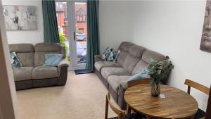 a living room with a couch and a table at Gables in Hither Green