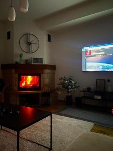 a living room with a fireplace and a flat screen tv at Maja Apartman Bjelasnica in Bjelašnica