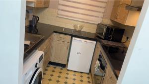 a small kitchen with a sink and a dishwasher at Gables in Hither Green