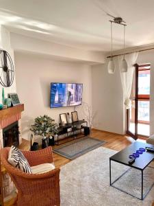 a living room with a fireplace and a tv at Maja Apartman Bjelasnica in Bjelašnica